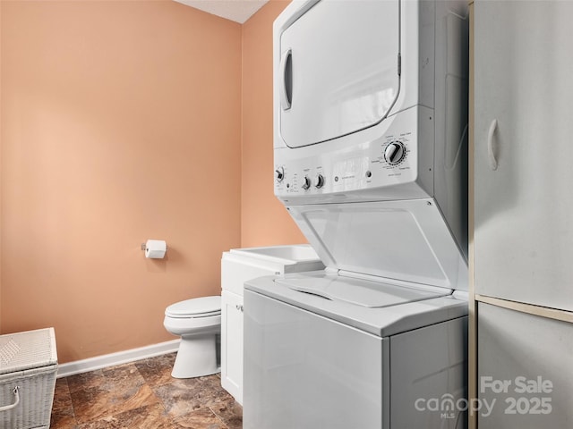 clothes washing area with stacked washer / dryer