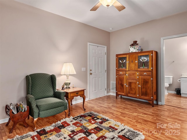 sitting room with light hardwood / wood-style floors and ceiling fan