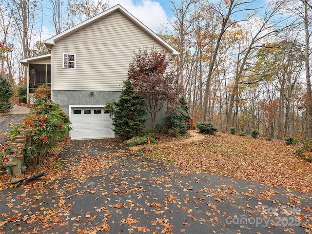 view of property exterior featuring a sunroom and a garage