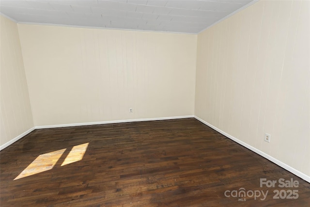 spare room featuring dark hardwood / wood-style floors and ornamental molding