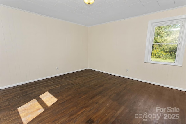 empty room featuring crown molding and dark hardwood / wood-style floors