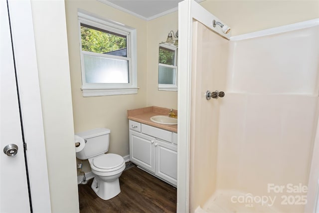 bathroom featuring wood-type flooring, vanity, toilet, walk in shower, and crown molding