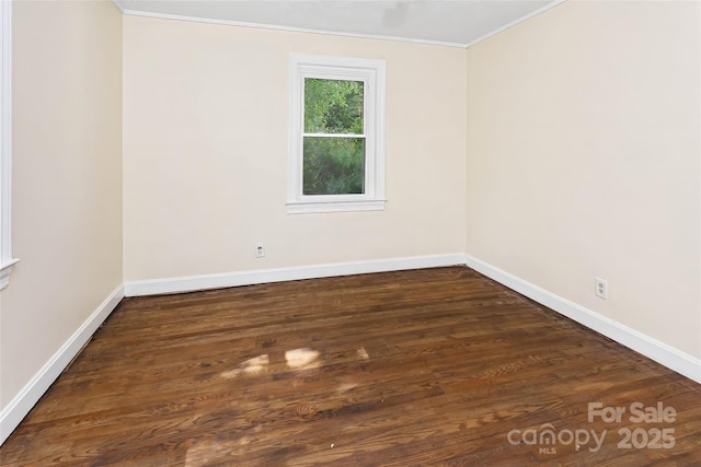 unfurnished room featuring dark wood-type flooring and crown molding