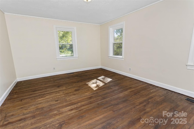 spare room featuring dark wood-type flooring and ornamental molding