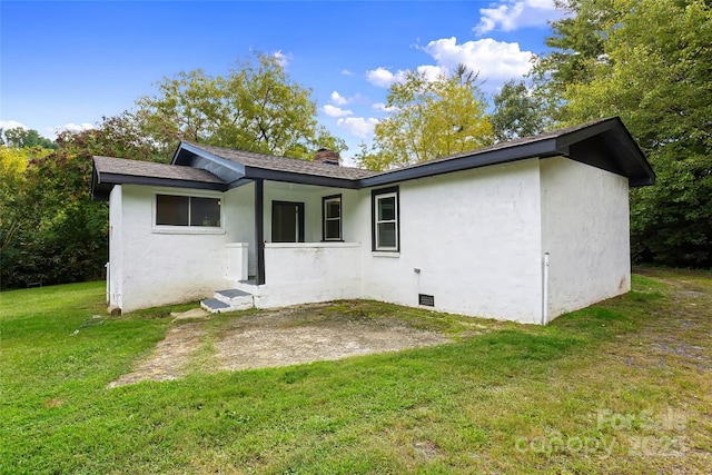 rear view of house with a yard