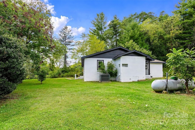 view of property exterior featuring a lawn and central AC unit