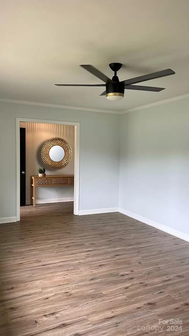 empty room featuring ceiling fan, hardwood / wood-style flooring, and crown molding