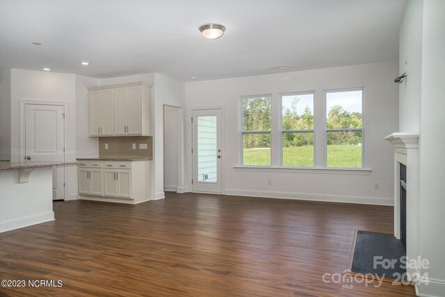 unfurnished living room featuring dark hardwood / wood-style floors