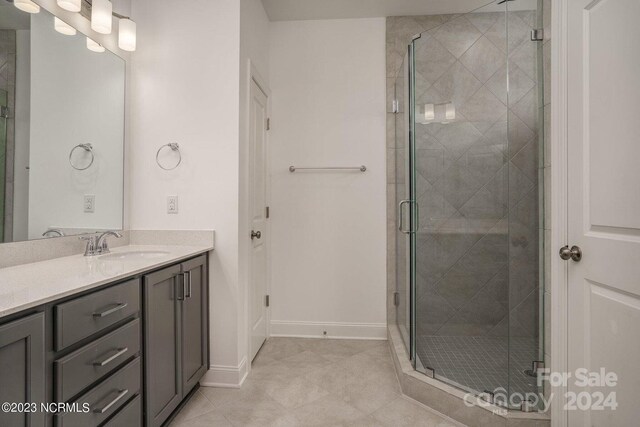 bathroom with tile patterned flooring, an enclosed shower, and vanity