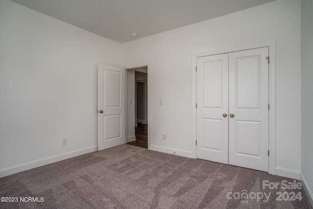 unfurnished bedroom with a closet and carpet flooring