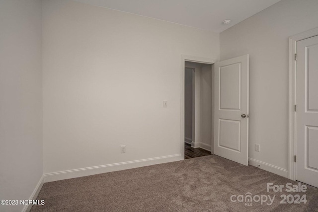 unfurnished bedroom with dark colored carpet