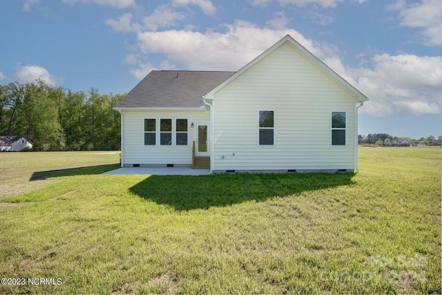 back of house with a lawn and a patio area