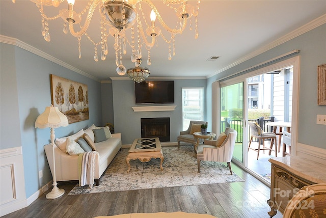 living room with a notable chandelier, wood-type flooring, and ornamental molding