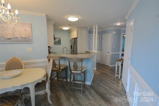 kitchen with high end refrigerator, pendant lighting, dark wood-type flooring, and white cabinets