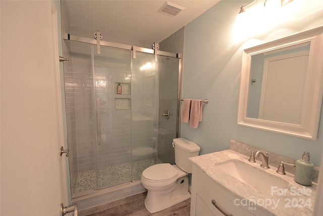 bathroom featuring vanity, hardwood / wood-style floors, toilet, and an enclosed shower