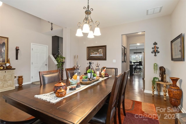 dining space featuring an inviting chandelier and dark wood-type flooring