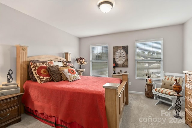 bedroom with light carpet and multiple windows