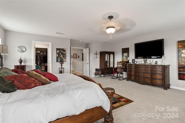 carpeted bedroom with a spacious closet, a closet, and ceiling fan