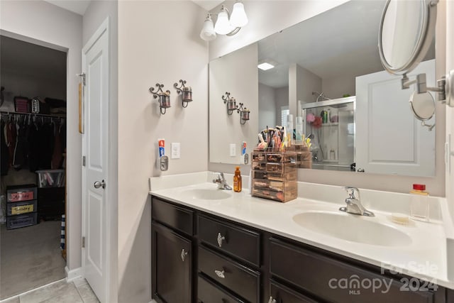 bathroom featuring tile patterned flooring, vanity, and an enclosed shower