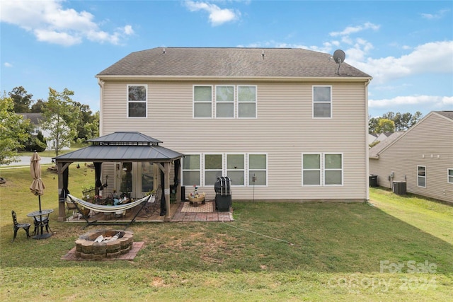 rear view of property with a fire pit, a patio area, a yard, central air condition unit, and a gazebo