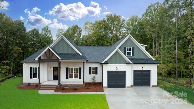 modern inspired farmhouse featuring a garage, a porch, and a front lawn