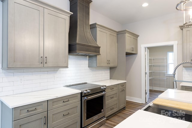 kitchen with tasteful backsplash, gray cabinets, dark hardwood / wood-style floors, custom range hood, and electric range