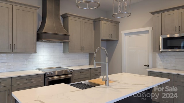 kitchen featuring custom exhaust hood, stainless steel appliances, hanging light fixtures, and tasteful backsplash