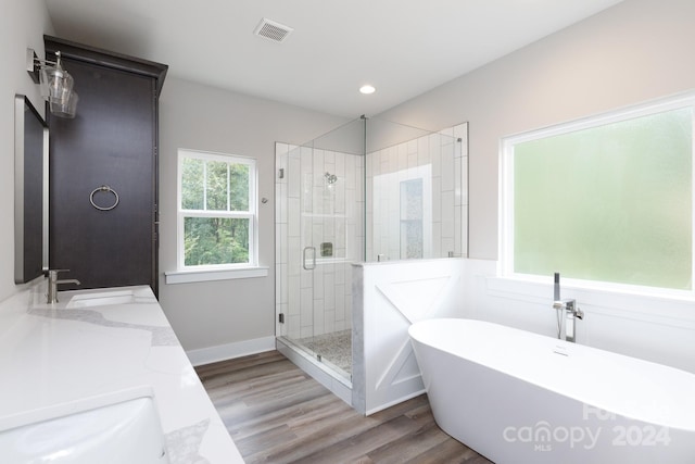 bathroom featuring independent shower and bath, hardwood / wood-style flooring, and vanity