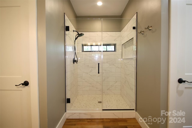 bathroom featuring an enclosed shower and hardwood / wood-style floors