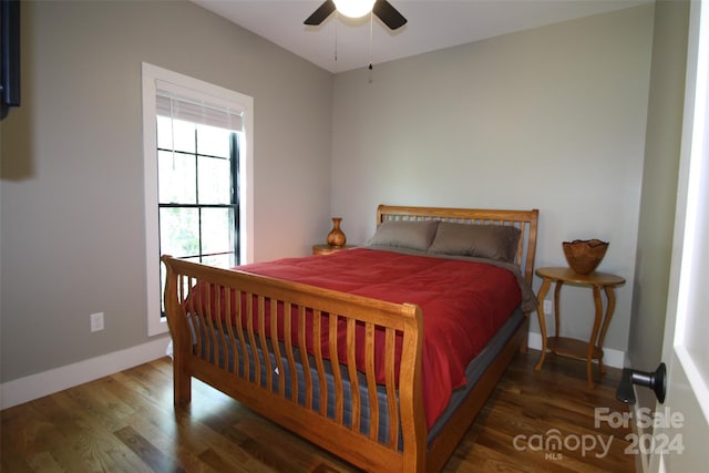 bedroom with dark hardwood / wood-style flooring and ceiling fan