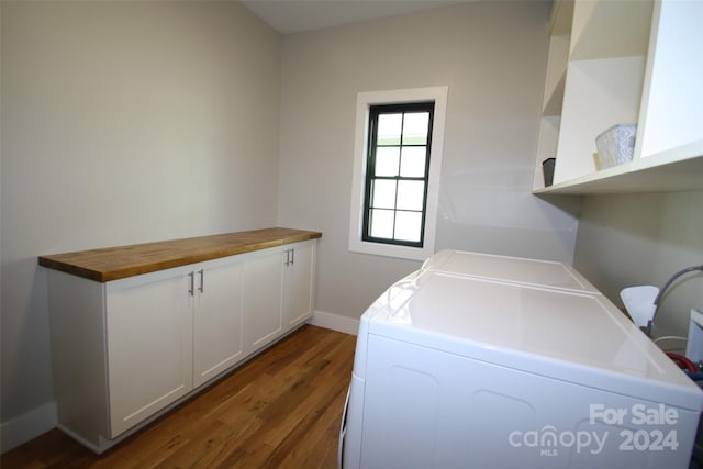 laundry room with washing machine and dryer, cabinets, and dark hardwood / wood-style flooring