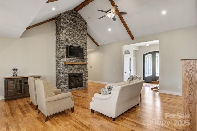 living room featuring arched walkways, a fireplace, light wood finished floors, high vaulted ceiling, and beamed ceiling