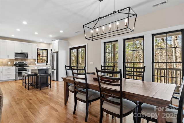 dining room featuring light wood-type flooring, visible vents, and recessed lighting