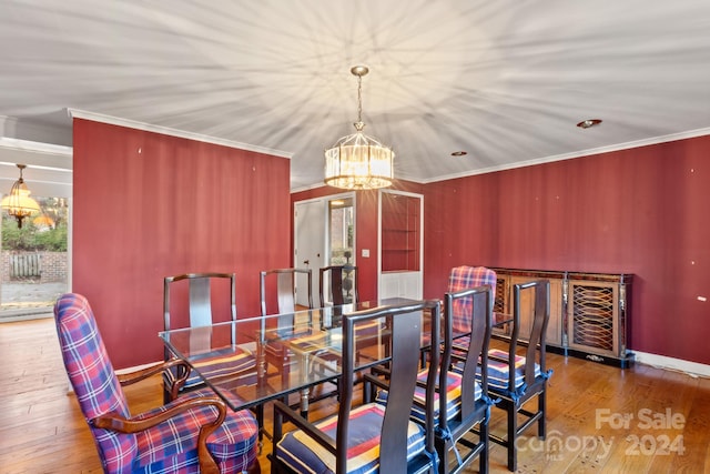 dining room featuring crown molding, an inviting chandelier, and hardwood / wood-style flooring