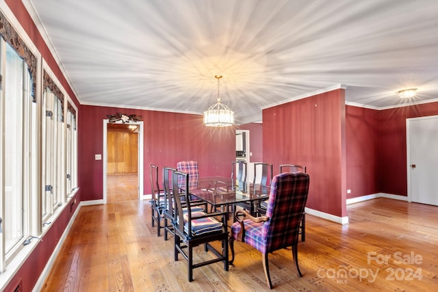 dining area with plenty of natural light, hardwood / wood-style floors, a notable chandelier, and ornamental molding