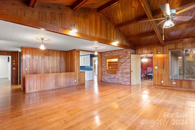 unfurnished living room featuring lofted ceiling with beams, light hardwood / wood-style floors, wooden walls, and wood ceiling