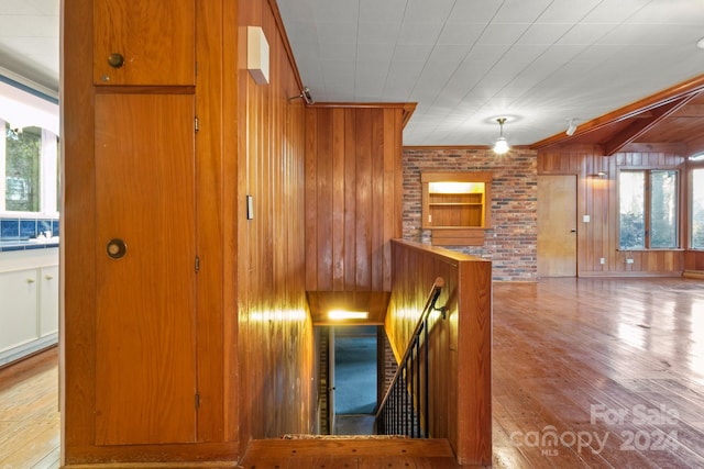 staircase featuring wood walls and hardwood / wood-style flooring