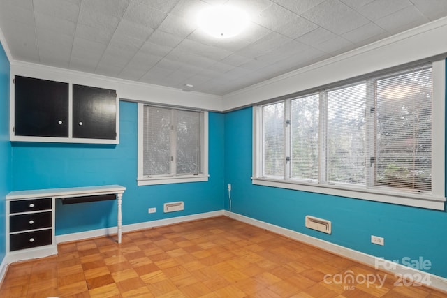 spare room with crown molding and parquet flooring