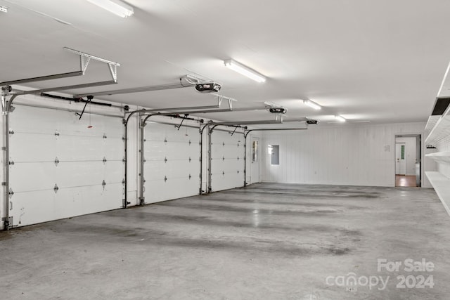 garage featuring electric panel and a garage door opener