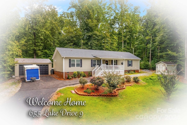 view of front of property featuring a porch, a storage shed, central AC, a front yard, and a garage