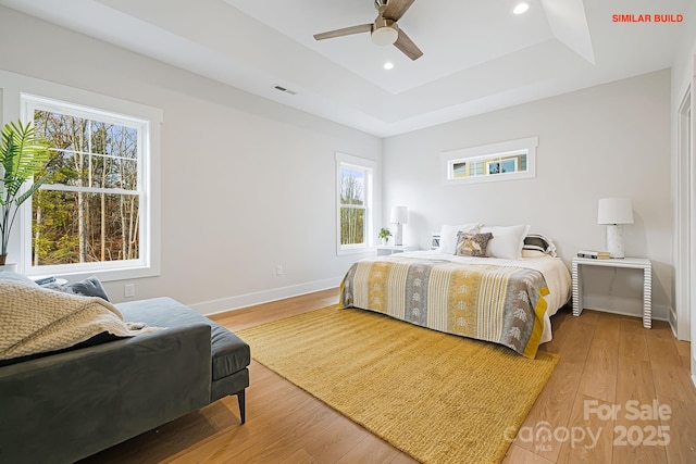 bedroom featuring visible vents, a raised ceiling, wood finished floors, and recessed lighting