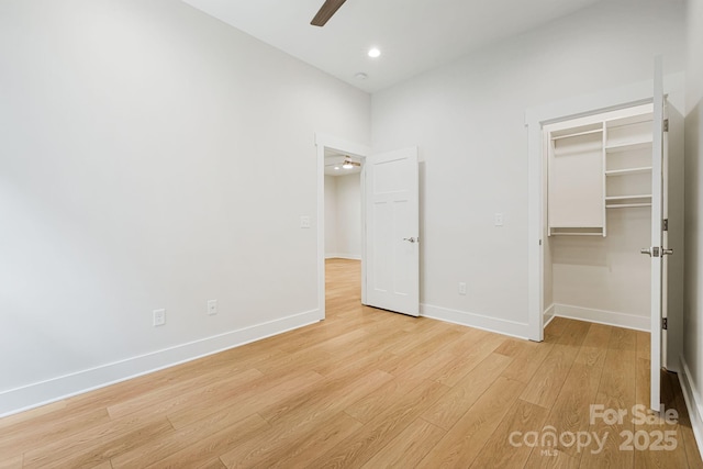 unfurnished bedroom featuring recessed lighting, a ceiling fan, baseboards, a spacious closet, and light wood finished floors