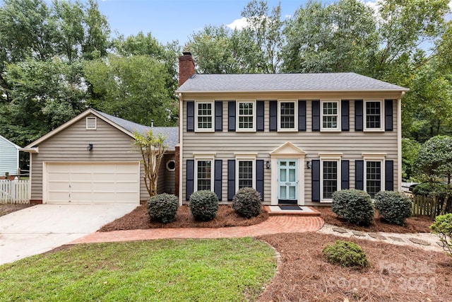 colonial house with a front yard and a garage