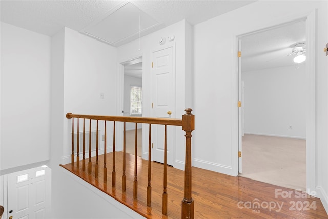 corridor featuring a textured ceiling and hardwood / wood-style floors