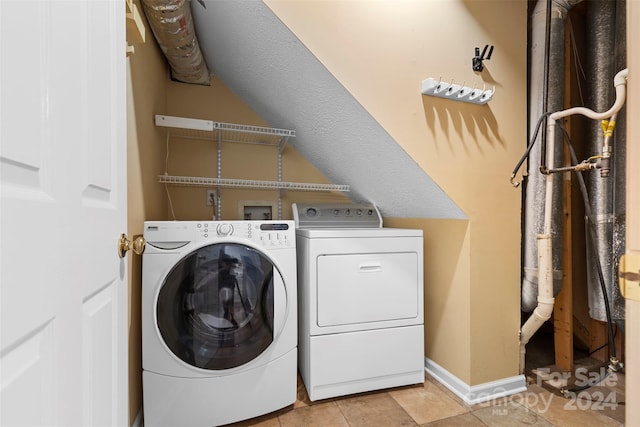 clothes washing area with washer and clothes dryer and light tile patterned floors