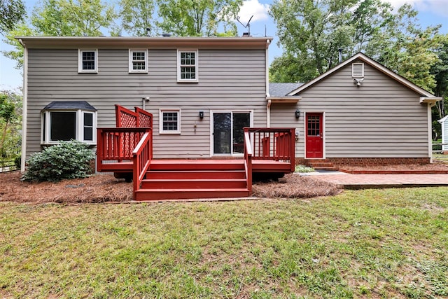 rear view of property featuring a yard and a wooden deck