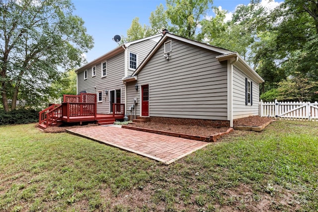 back of property with a deck, a yard, and a patio area