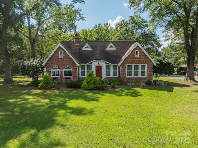 cape cod house with a front yard