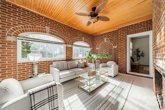 carpeted living room with wood ceiling, ceiling fan, and brick wall