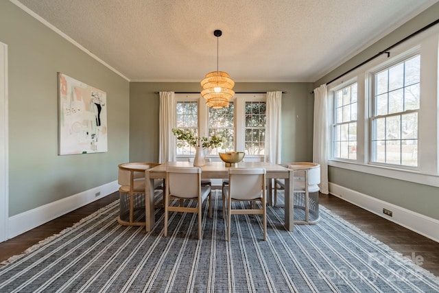 dining space with crown molding, dark hardwood / wood-style floors, a textured ceiling, and an inviting chandelier